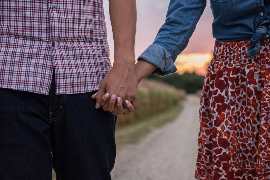 Couple holding hands in a corn field